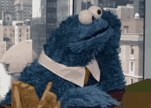 Cookie Monster gazing pensively out of a city window while he waits